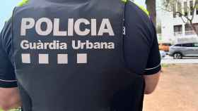 Uno de los agentes de la Guardia Urbana de Badalona de espalda