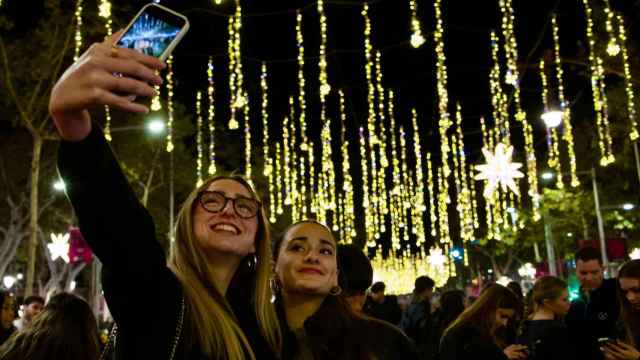 Dos barcelonesas haciéndose una foto con las luces de Navidad de paseo de Gràcia