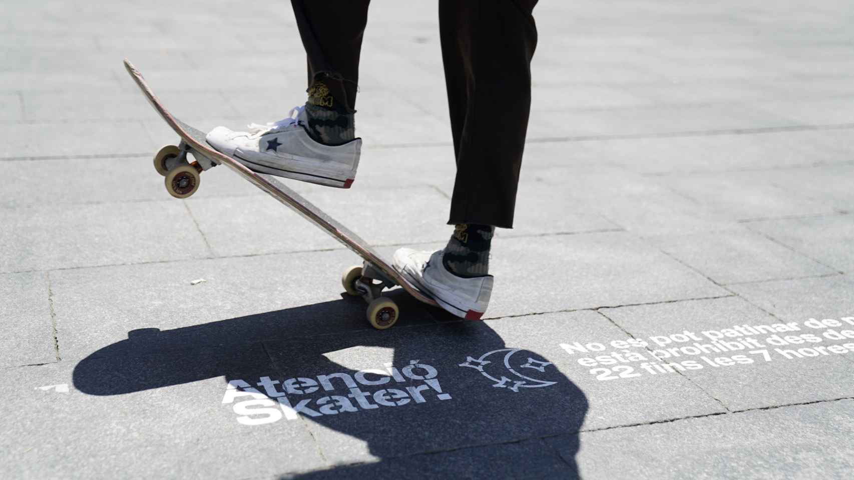 Un ‘skater’ patinando en las calles del Raval, encima de una de las señales del Ayuntamiento de Barcelona