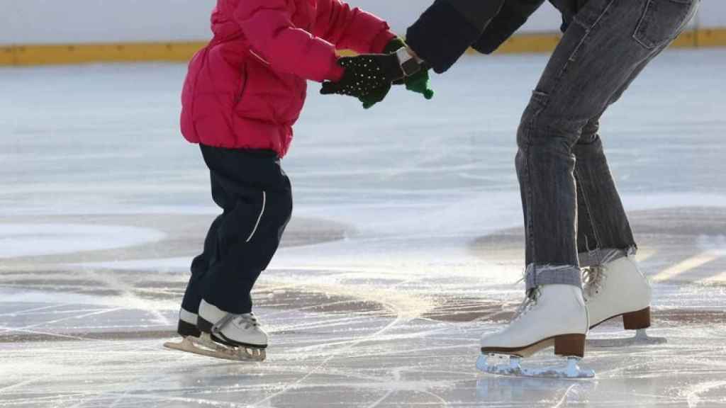 Imagen archivo de una niña y una madre en una pista de hielo