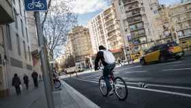 Un ciclista circula por el carril bici de la calle de Sant Antoni Maria Claret, en su confluencia con el paseo de Maragall