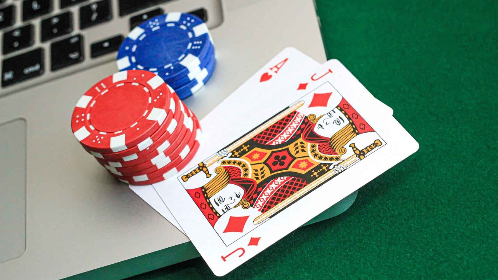 Cartas y fichas de póker sobre un portátil