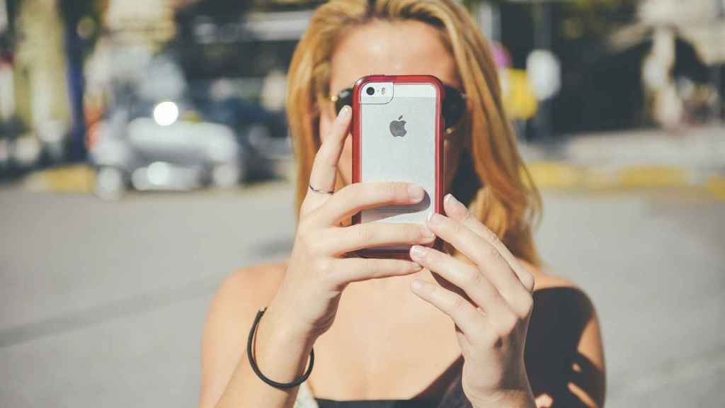 Una mujer fotografía con su Iphone