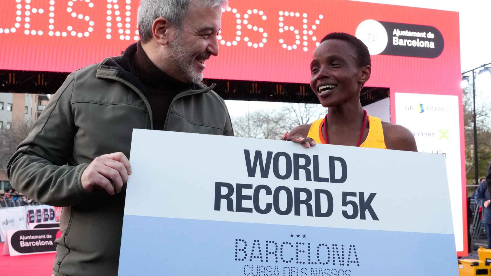 El alcalde de Barcelona, Jaume Collboni, posa junto a la atleta keniana Beatice Chebet, que ha vencido y batido el récord del mundo de los 5 kilómetros en ruta durante la popular Cursa dels Nassos de Barcelona
