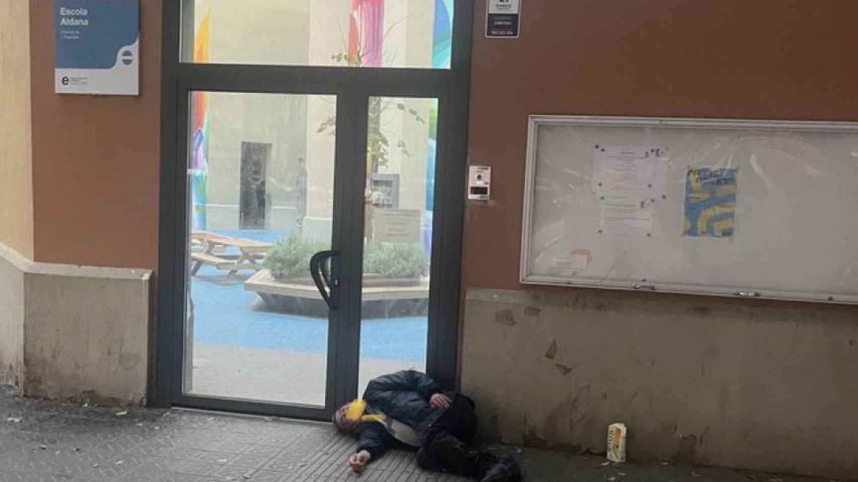 Una persona sintecho durmiendo en las puertas de la Escola Aldana de Sant Antoni