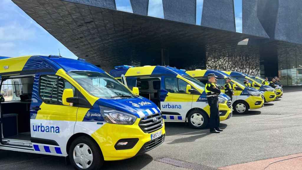 Agentes de la Guardia Urbana junto a sus vehículos