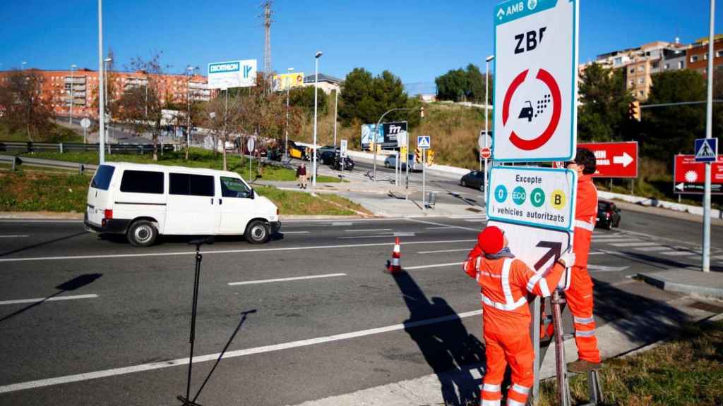 Técnicos colocan un cartel de la ZBE en L'Hospitalet