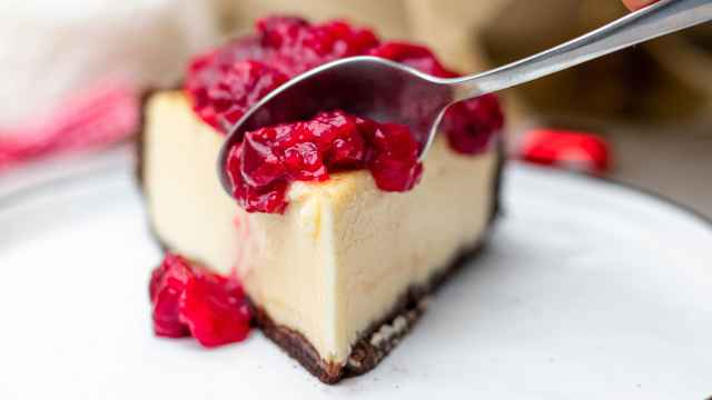 Porción de pastel de queso con mermelada de arándanos