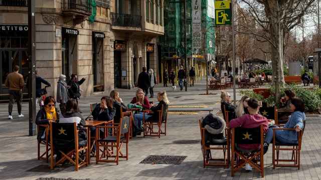 Gente tomando algo en una terraza en el paseo Sant Joan de Barcelona