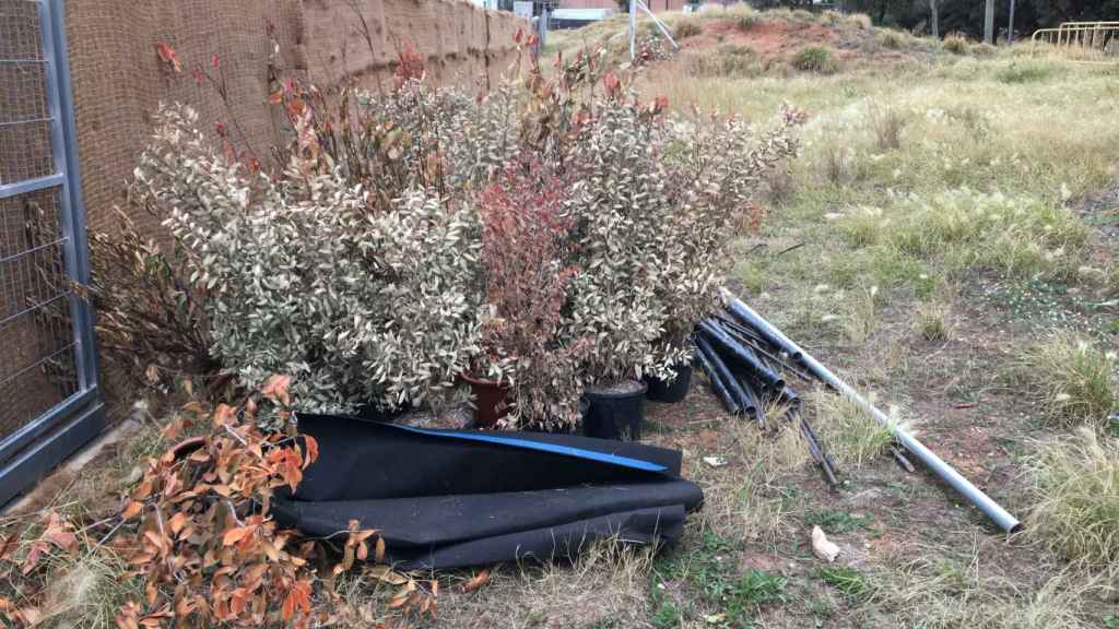 Materiales y macetas amontonadas en un acceso a los jardines