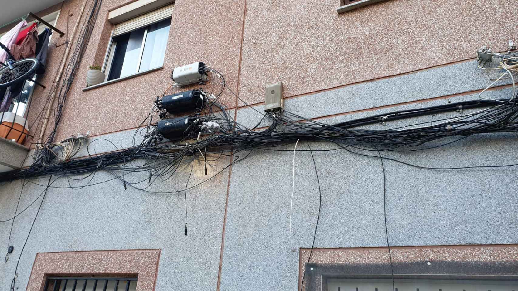 Cables colgando de la fachada exterior de los edificios del Besòs