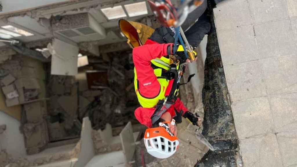 Un bombero de la GRAE accediendo al interior del edificio derrumbado en Badalona