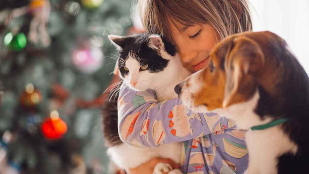 Una joven posa con sus mascotas, un perro y un gato