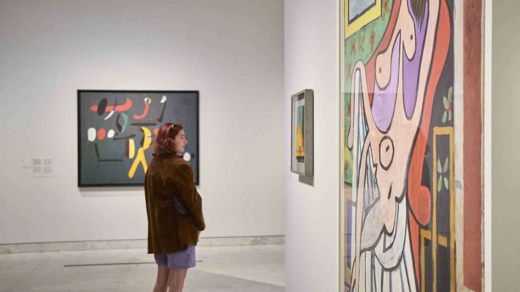 Una chica mirando un cuadro de la exposición Miró-Picasso
