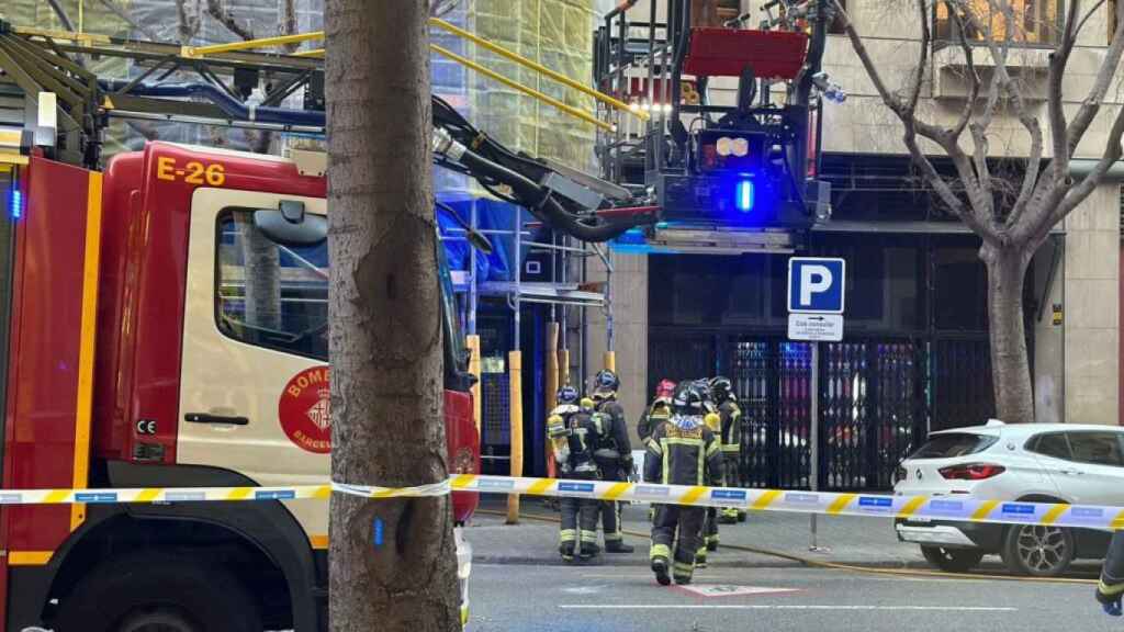 Dotaciones de bomberos trabajan en la extinción del incendio en el Eixample