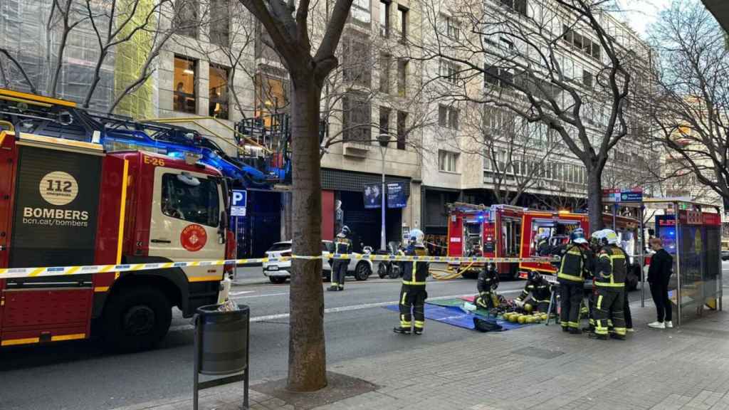 Dotaciones de bomberos trabajan en la extinción del incendio en el Eixample