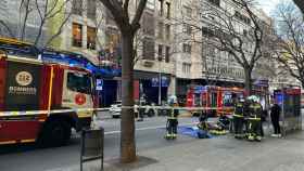 Dotaciones de bomberos trabajan en la extinción del incendio en el Eixample