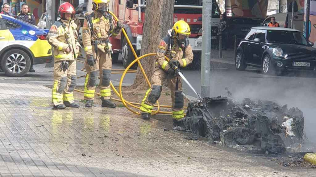 Bomberos trabajando en la extinción del fuego de un contenedor en Sant Adrià