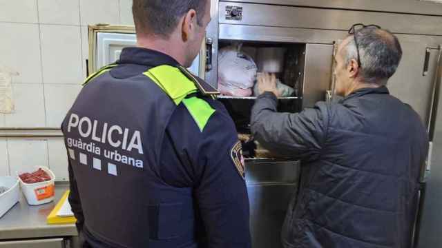 Imagen de un gente de la Guardia Urbana inspeccionando los alimentos en mal estado en un restaurante de Sant Andreu