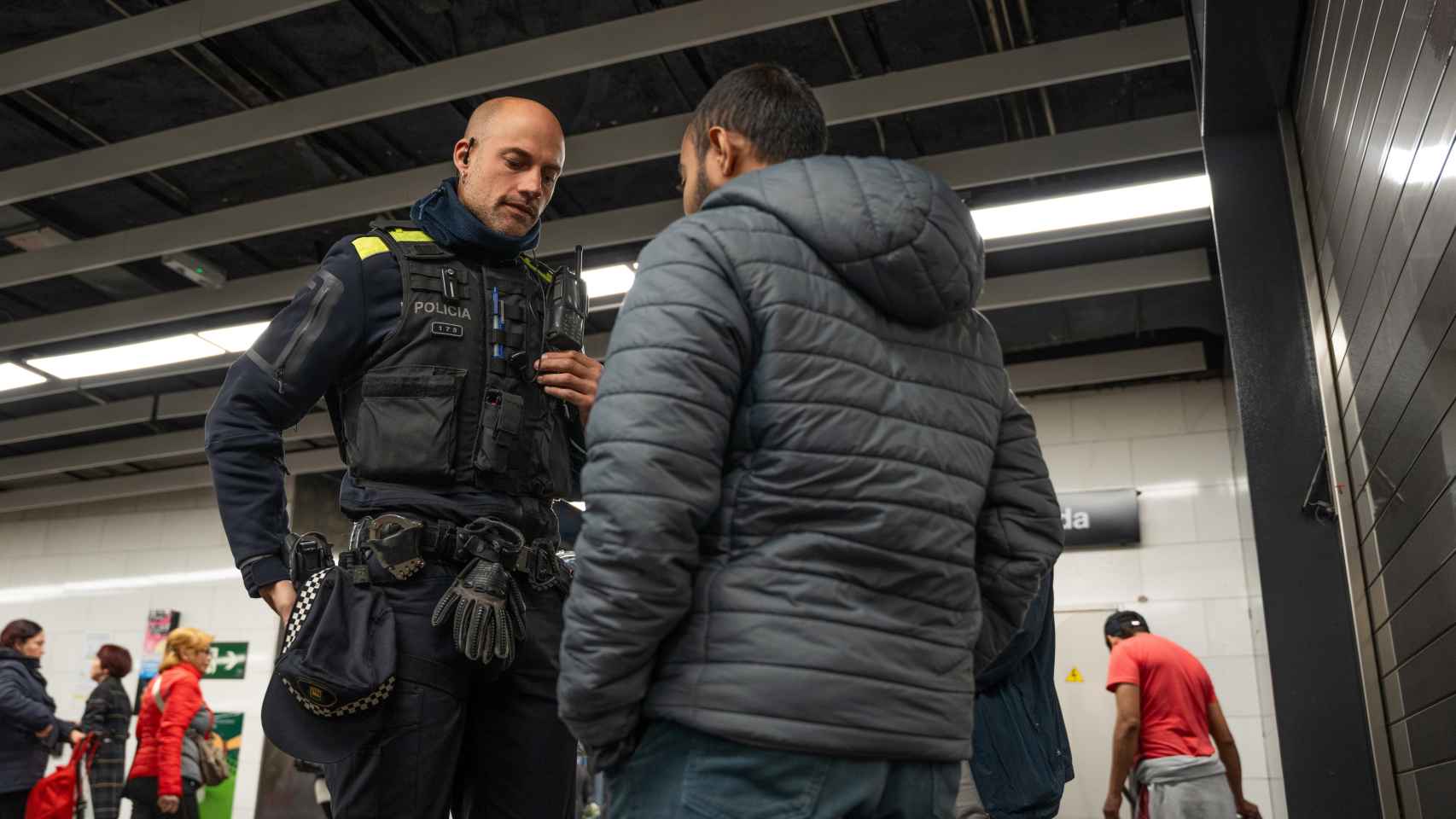 Uno de los agentes de la Policía Local de Santa Coloma con un usuario del metro en Fondo