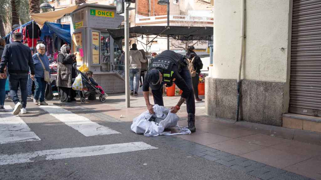 Agentes de la Policía Local de Santa Coloma requisando mercancía ilegal en el mercadillo de Fondo