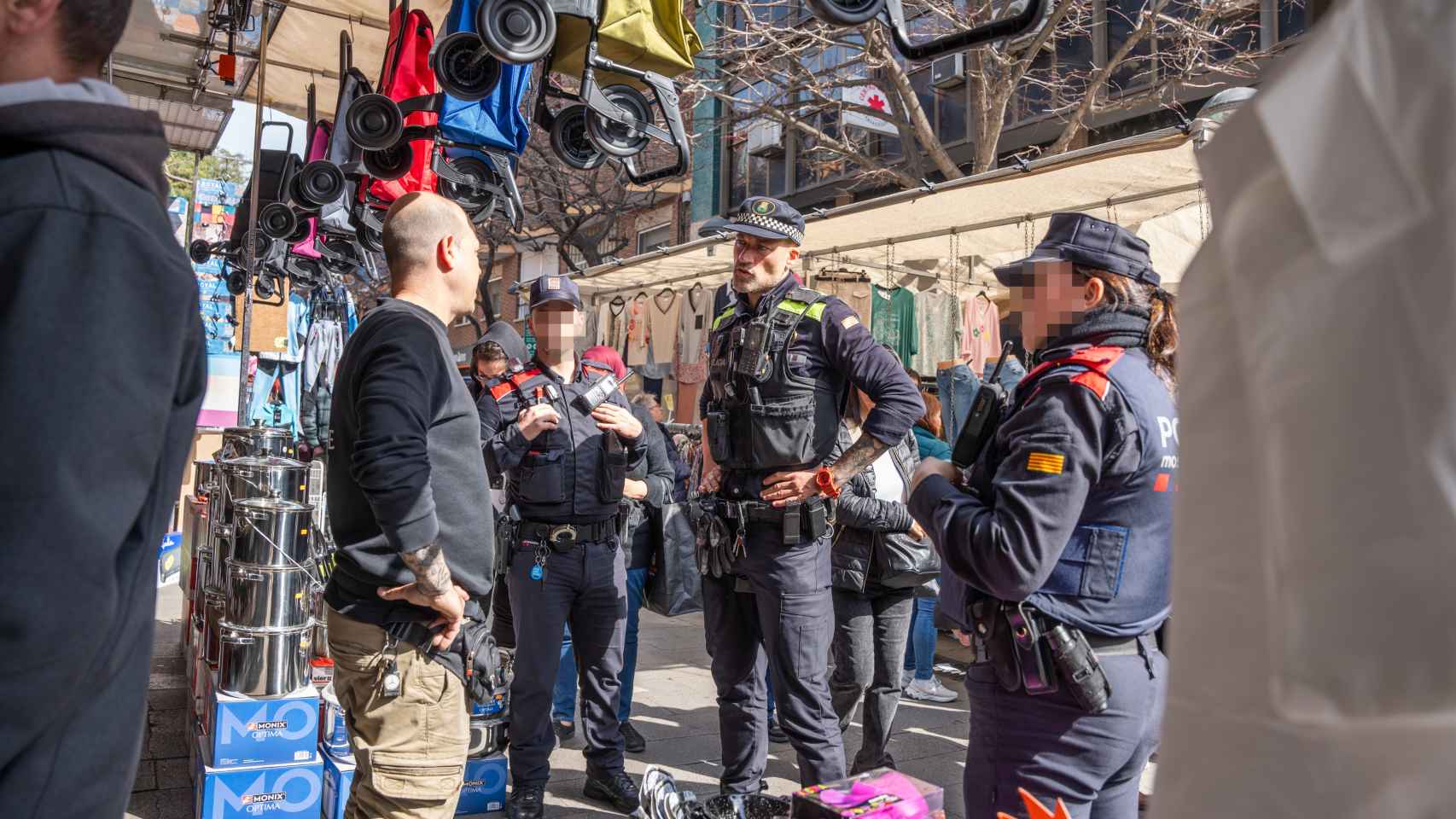 Agentes de la Policía Local de Santa Coloma y mossos hablando con un paradista del mercadillo de Fondo