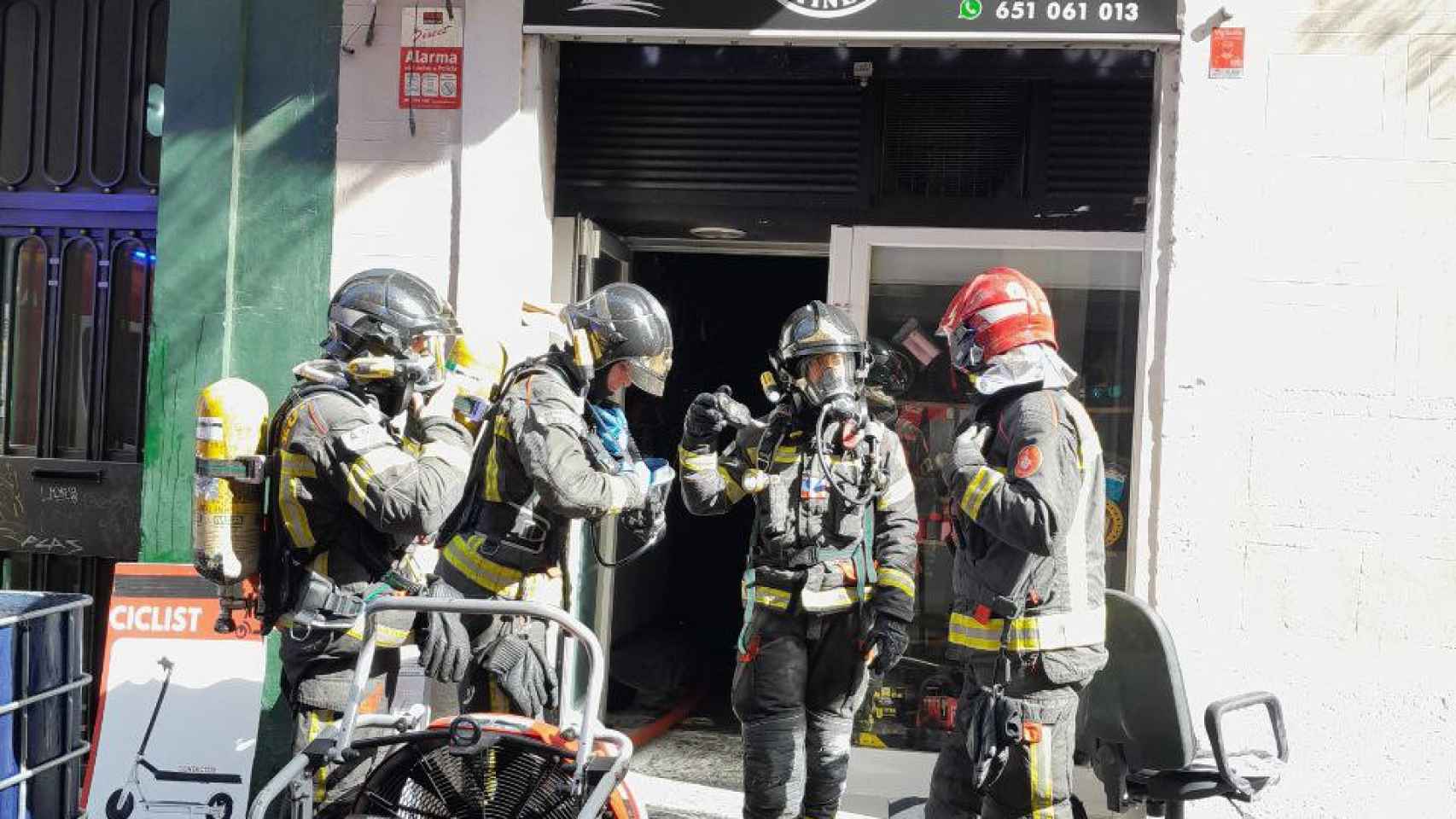 Imagen de las dotaciones de bomberos junto a la puerta del taller