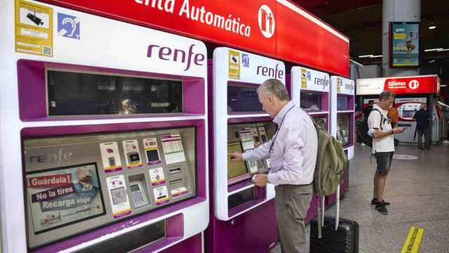 Un pasajero comprando un billete en una máquina de venta automática de Renfe