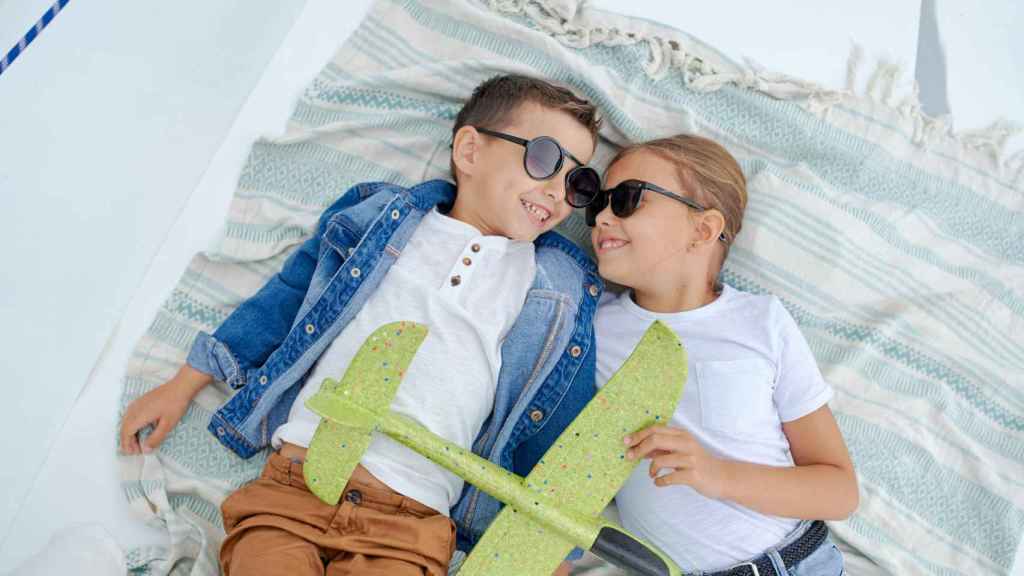 Dos niños se protegen los ojos con gafas de sol mientras juegan