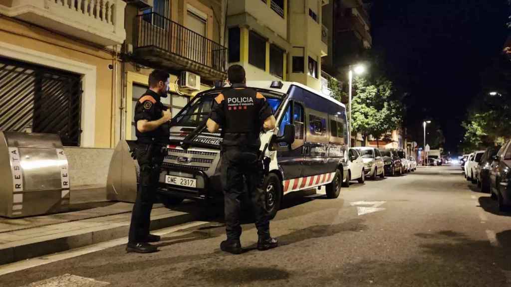 Agentes de los Mossos d'Esquadra frente a un furgón policial en un operativo