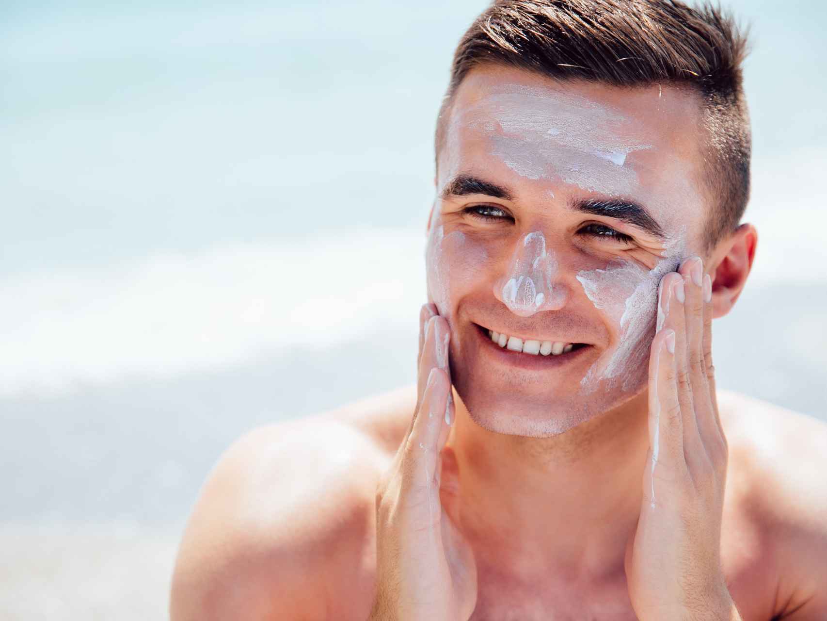 Un hombre se aplica crema solar en la cara para poroeger la piel