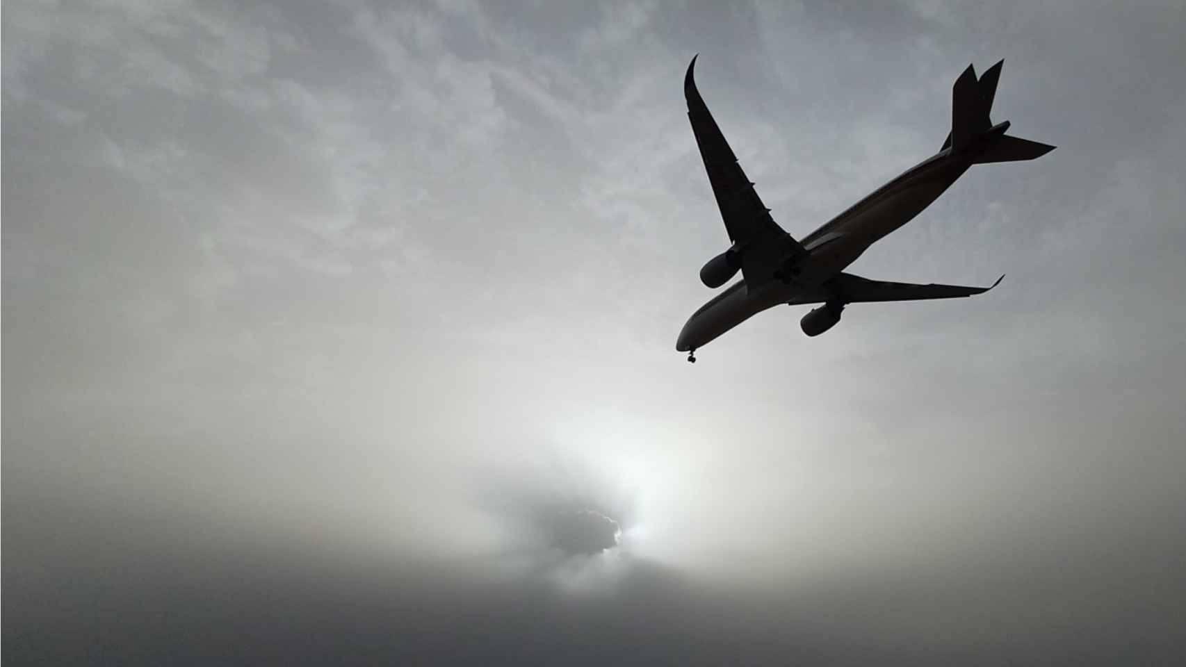 Un avión atraviesa el cielo de Gavà, enturbiado por la calima, durante este lunes