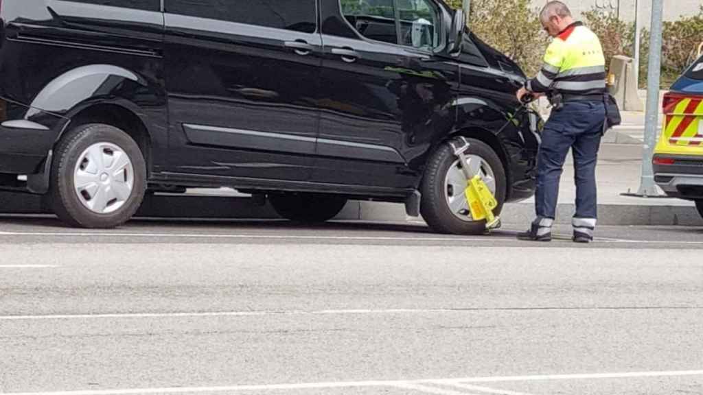 Un mosso multando al conductor de un vehículo VTC sin licencia en el Aeropuerto de Barcelona