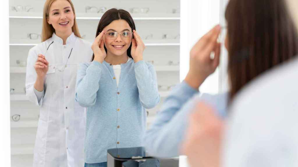 Una niña se prueba unas gafas en una óptica