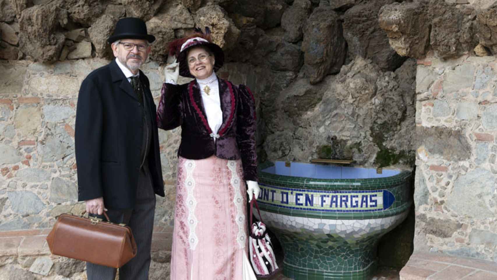 Dos personas se fotografían junto a la fuente de la plaza de la Font d'en Fargues