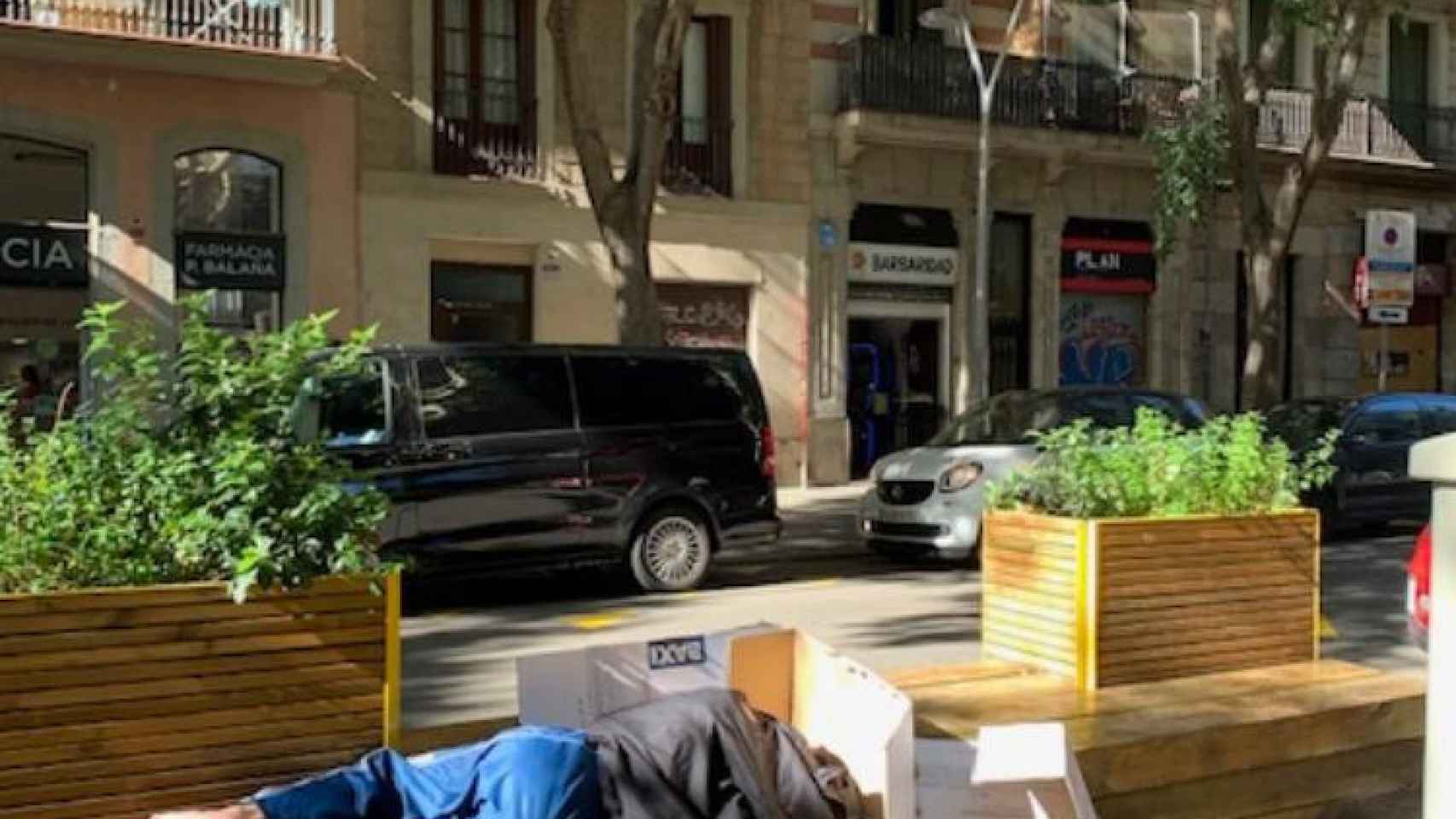 Un hombre sin hogar durmiendo en la superilla de Sant Antoni