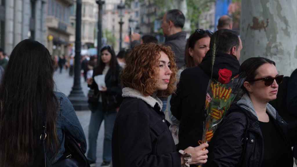 Una joven sostiene una rosa en el paseo de Gràcia