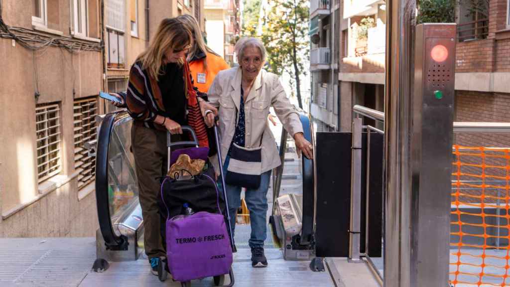 Gente mayor utilizando las escaleras mecánicas de la Baixada de la Glòria