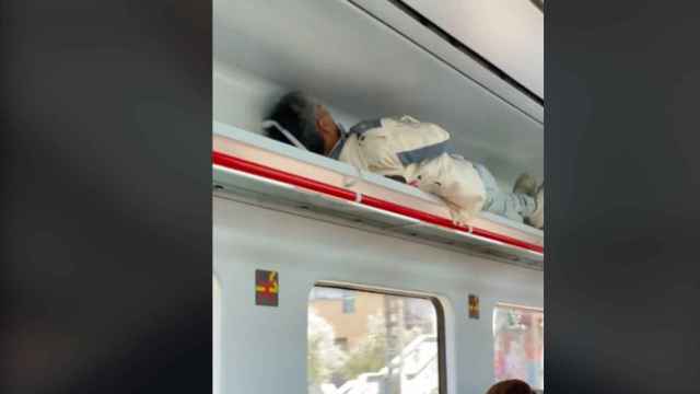 Un hombre duerme en el compartimento de equipaje de un tren de Rodalies