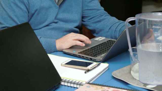 Un hombre accede a internet con un portátil