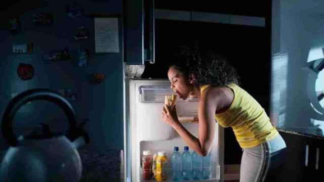Una joven come con ansia durante la noche