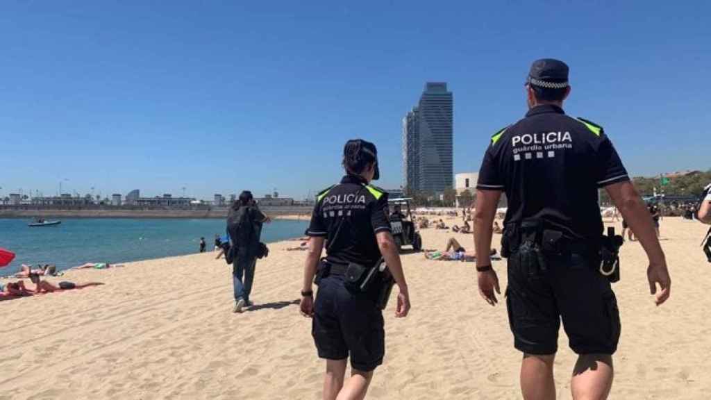 Dos agentes de la Guardia Urbana patrullando una playa de Barcelona