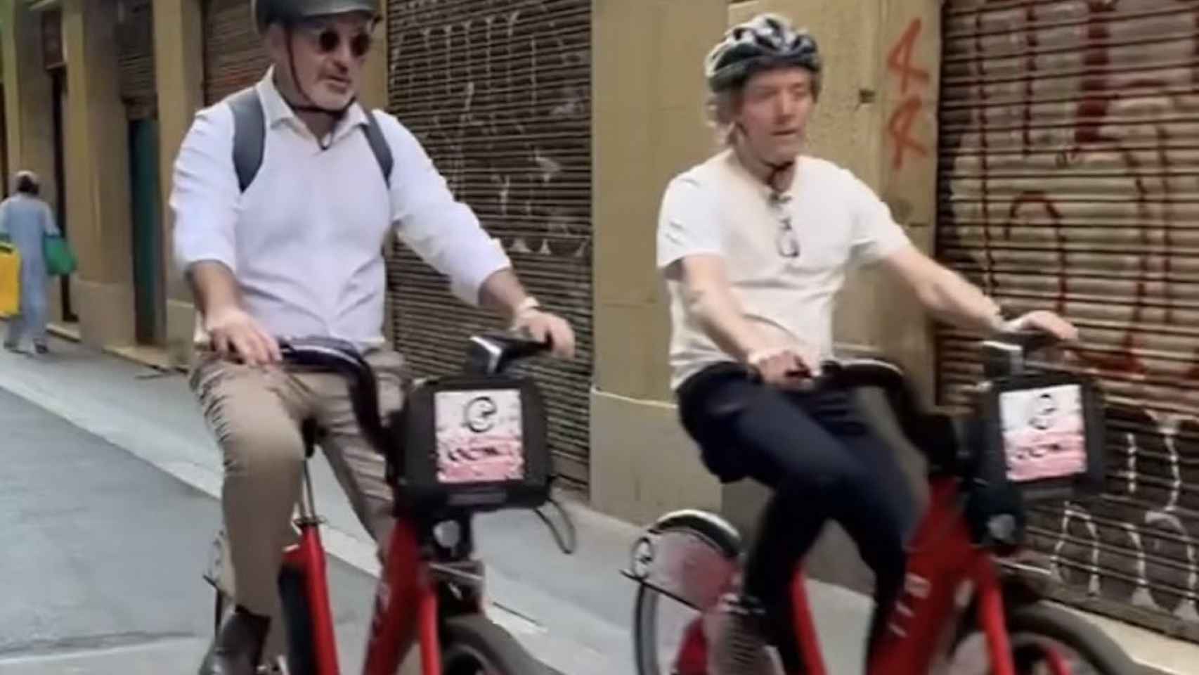 Jaume Collboni y David Escudé circulando en bicicleta en la calle de Avinyó