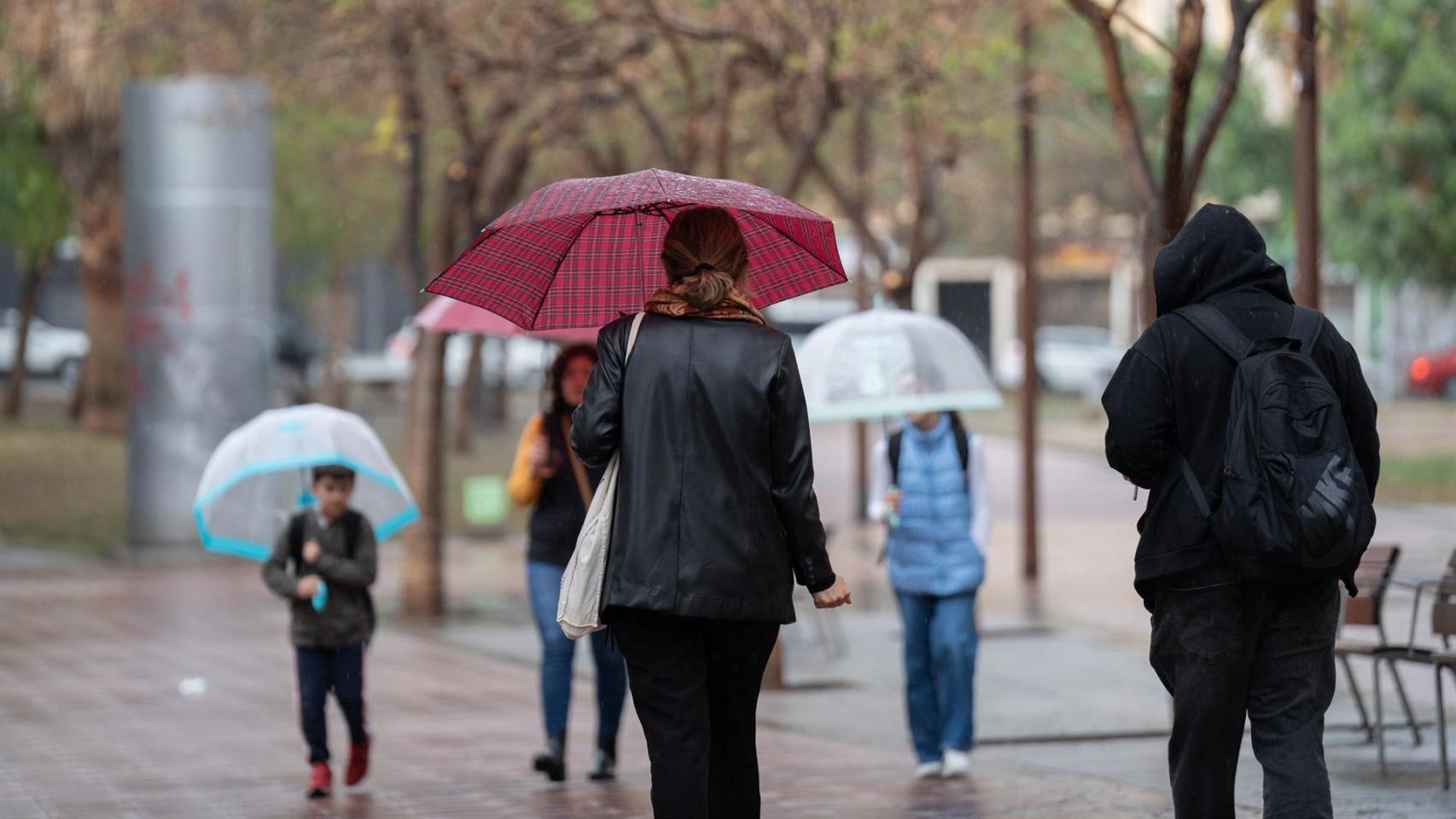 Varias presonas protegiéndose de la lluvia