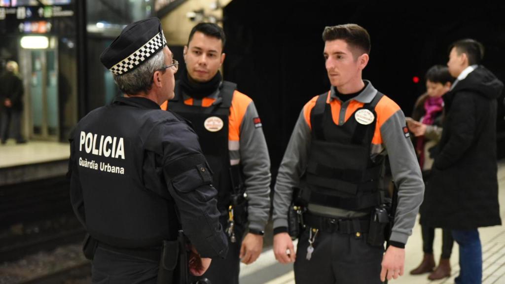 Vigilantes de seguridad junto a un agente de la Guardia Urbana en Barcelona