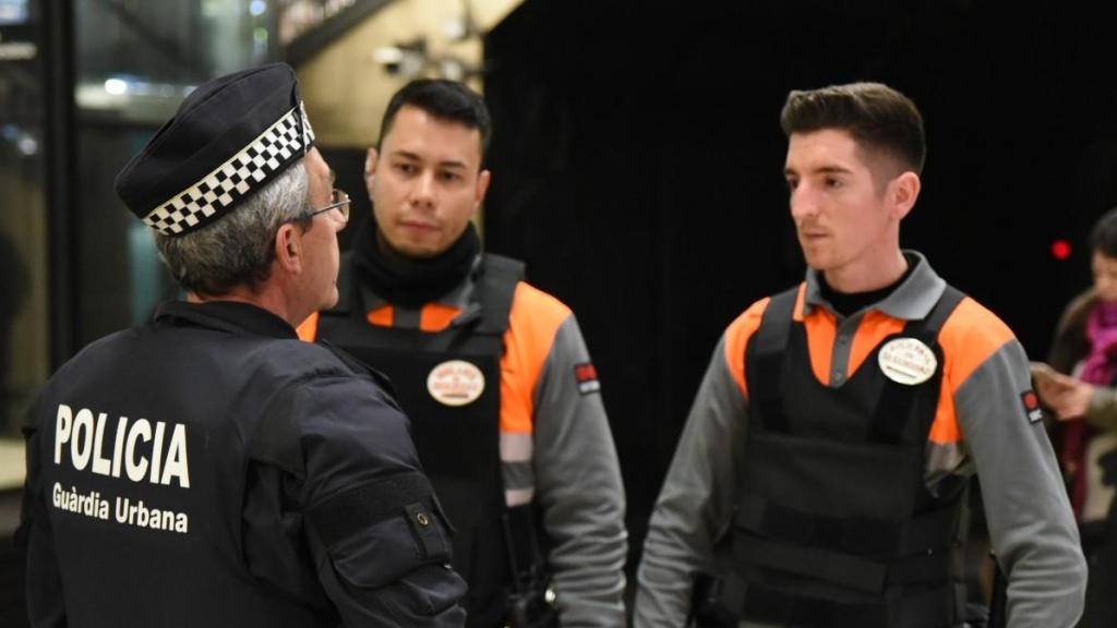 Vigilantes de seguridad junto a un agente de la Guardia Urbana en Barcelona