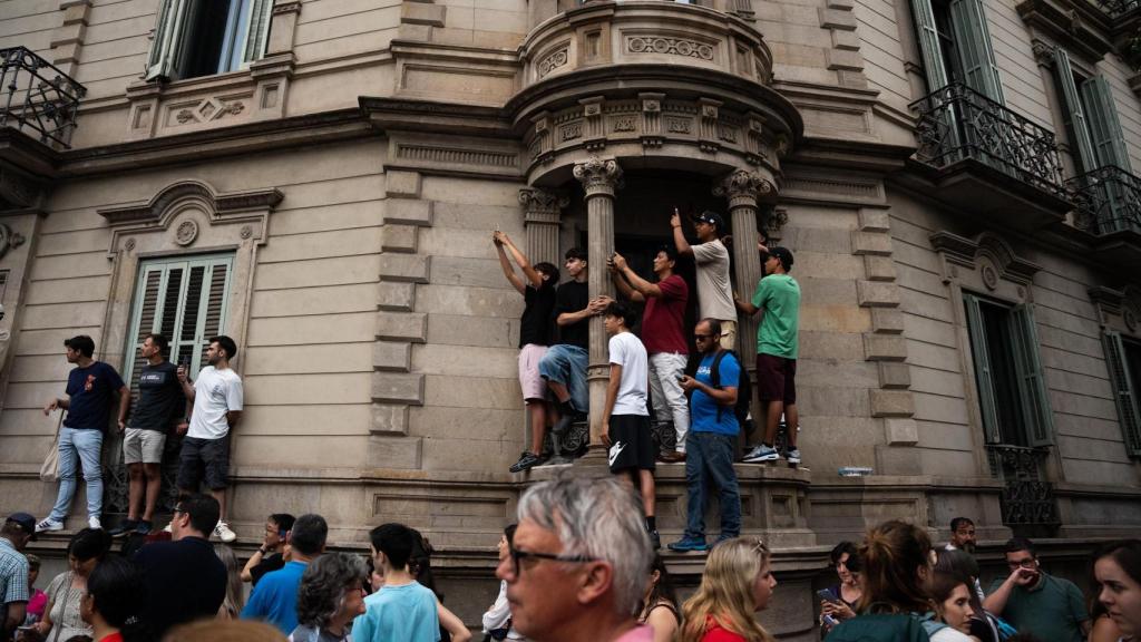 Aficionados de la Fórmula 1 subidos en los edificios de paseo de Gràcia para poder ver a los bólidos