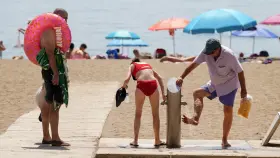 Bañistas haciendo uso de los lavapiés en una playa