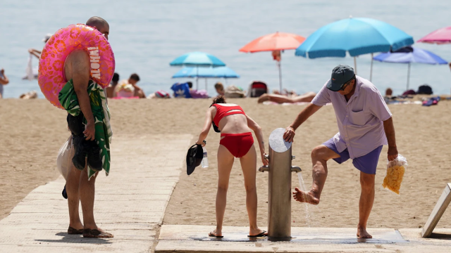 Bañistas haciendo uso de los lavapiés en una playa de Barcelona