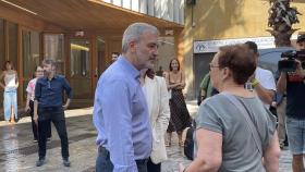 Jaume Collboni conversa con una vecina de Ciutat Vella delante del edificio del nuevo centro de viviendas temporales